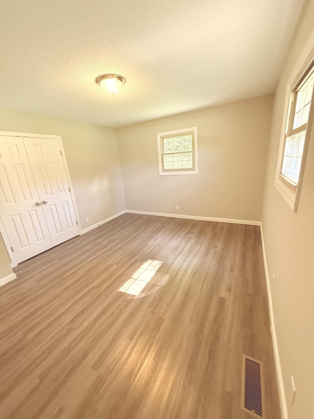 551 Maple Ter, Lafayette, TN 37083 - unfurnished bedroom featuring light wood-style flooring, baseboards, a textured ceiling, and a closet