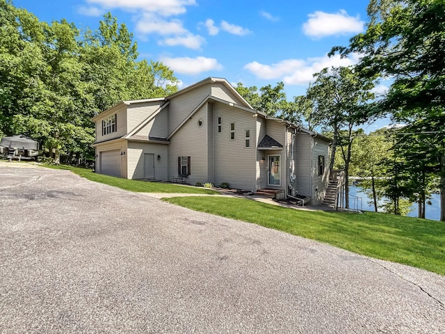 21 Heron Pt, Cadiz, KY 42211 - view of side of home featuring an attached garage, asphalt driveway, entry steps, and a lawn
