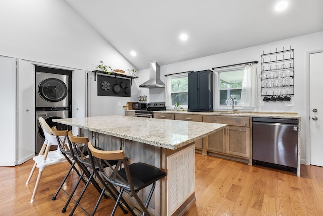 515 S Cedar Ln, Pulaski, TN 38478 - kitchen with appliances with stainless steel finishes, exhaust hood, stacked washer / drying machine, a sink, and lofted ceiling