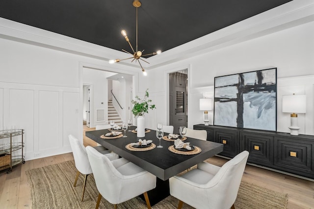 117 Alton Rd, Nashville, TN 37205 - dining area featuring a decorative wall, a chandelier, light wood finished floors, stairway, and a wainscoted wall