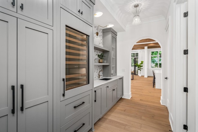 117 Alton Rd, Nashville, TN 37205 - bar featuring arched walkways, light wood-style floors, a sink, wine cooler, and baseboards