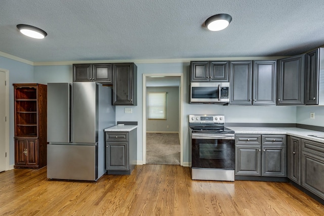 2023 Denise Dr, Columbia, TN 38401 - kitchen with stainless steel appliances, light countertops, a textured ceiling, light wood-style floors, and crown molding