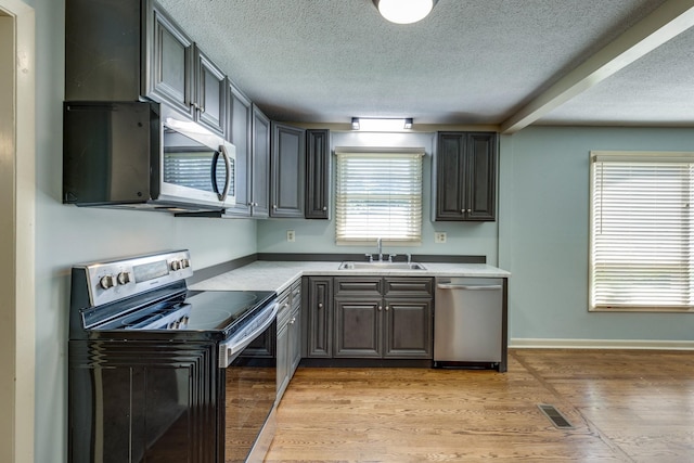 2023 Denise Dr, Columbia, TN 38401 - kitchen featuring appliances with stainless steel finishes, a sink, a textured ceiling, light countertops, and light wood-style floors