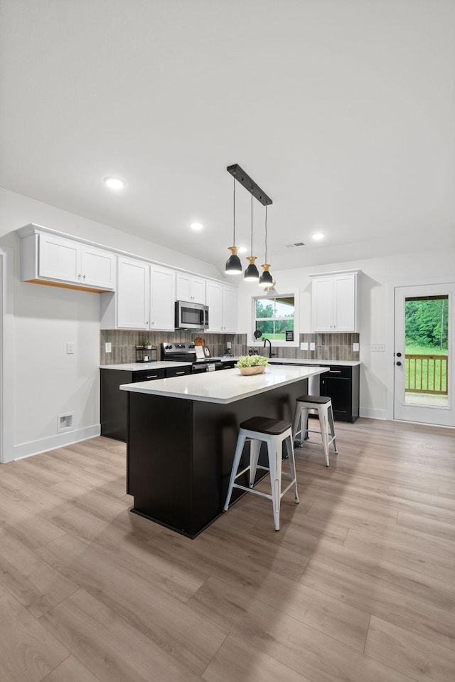 201 Dewberry Ct, Clarksville, TN 37042 - kitchen with appliances with stainless steel finishes, a kitchen island, a sink, white cabinetry, and light wood-style flooring