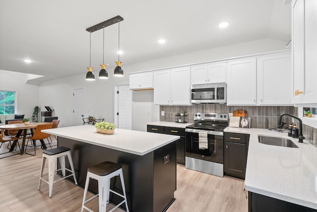 185 Dewberry Ct, Clarksville, TN 37042 - kitchen featuring stainless steel appliances, a sink, white cabinetry, tasteful backsplash, and light wood-style flooring