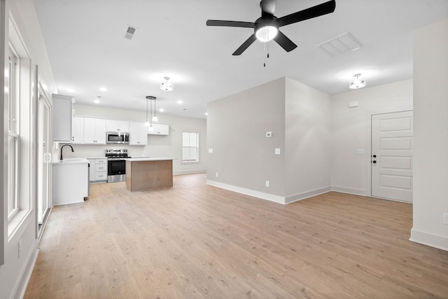 193 Dewberry Ct, Clarksville, TN 37042 - unfurnished living room with light wood finished floors, a ceiling fan, baseboards, recessed lighting, and a sink