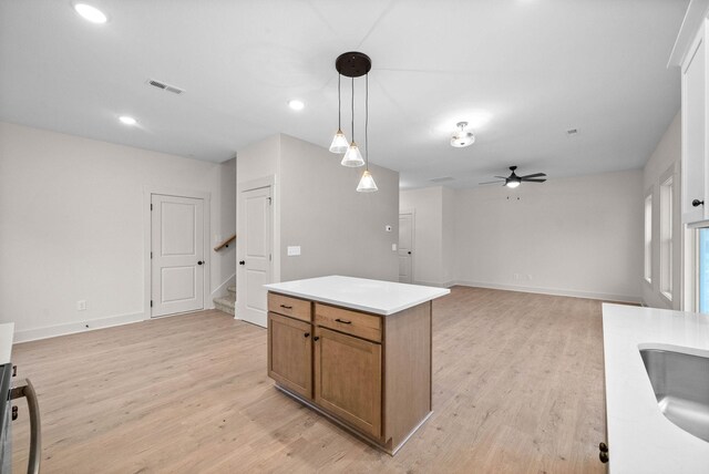 193 Dewberry Ct, Clarksville, TN 37042 - kitchen featuring brown cabinetry, light wood-style floors, hanging light fixtures, a ceiling fan, and light countertops