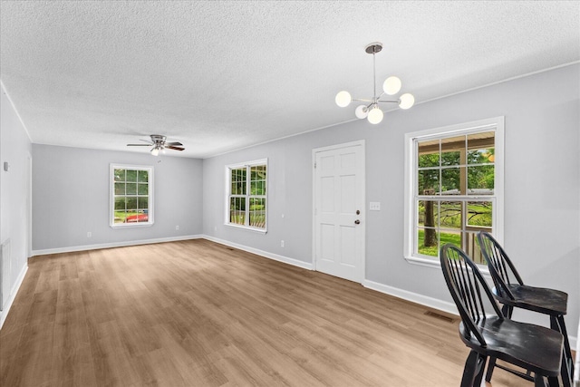 724 Shelly Ln, Rossville, GA 30741 - unfurnished living room with a textured ceiling, light wood finished floors, ceiling fan, and a chandelier