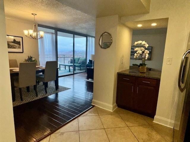 1131 Stringers Ridge Rd Unit 11K, Chattanooga, TN 37405 - dining room with a wall of windows, baseboards, a chandelier, a textured ceiling, and light tile patterned floors