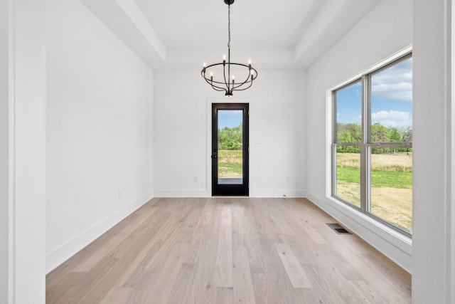 827 Oconner St, Smithville, TN 37166 - unfurnished dining area featuring a chandelier, a tray ceiling, light wood-type flooring, and baseboards