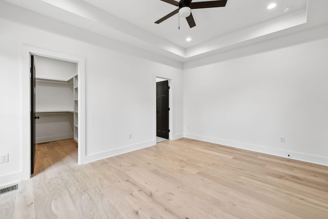 827 Oconner St, Smithville, TN 37166 - unfurnished bedroom featuring a raised ceiling, light wood-style flooring, a walk in closet, baseboards, and recessed lighting