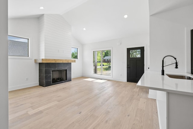 827 Oconner St, Smithville, TN 37166 - unfurnished living room featuring a sink, high vaulted ceiling, a fireplace, baseboards, and light wood-style flooring