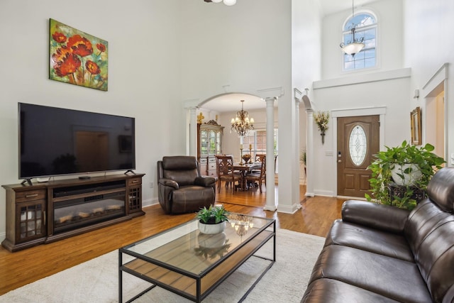 5405 Cliffstone Dr, Smyrna, TN 37167 - living area with decorative columns, a chandelier, a towering ceiling, arched walkways, and healthy amount of natural light