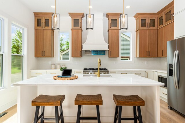 311 N 9th St, Nashville, TN 37206 - kitchen with stainless steel fridge, decorative backsplash, brown cabinetry, light countertops, and premium range hood