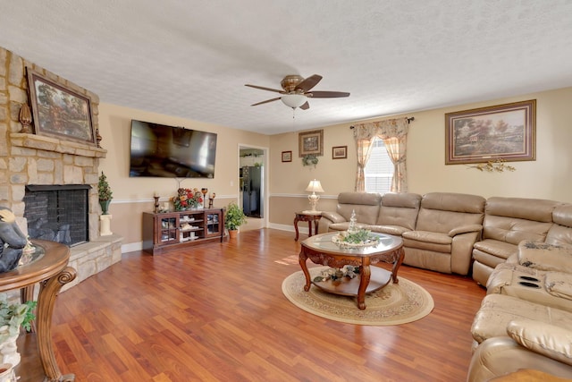 108 Dalewood Cir, Chickamauga, GA 30707 - living room featuring a ceiling fan, a textured ceiling, wood finished floors, and a stone fireplace