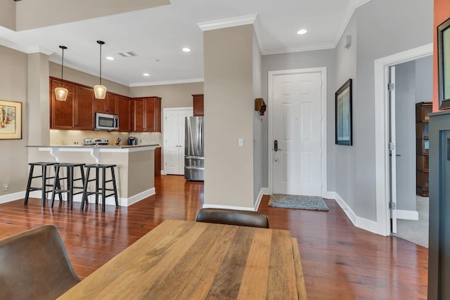307 Seven Springs Way Unit 402, Brentwood, TN 37027 - kitchen with appliances with stainless steel finishes, a peninsula, dark wood-type flooring, light countertops, and crown molding