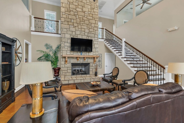 307 Seven Springs Way Unit 402, Brentwood, TN 37027 - living area featuring a stone fireplace, ornamental molding, wood finished floors, stairway, and a towering ceiling