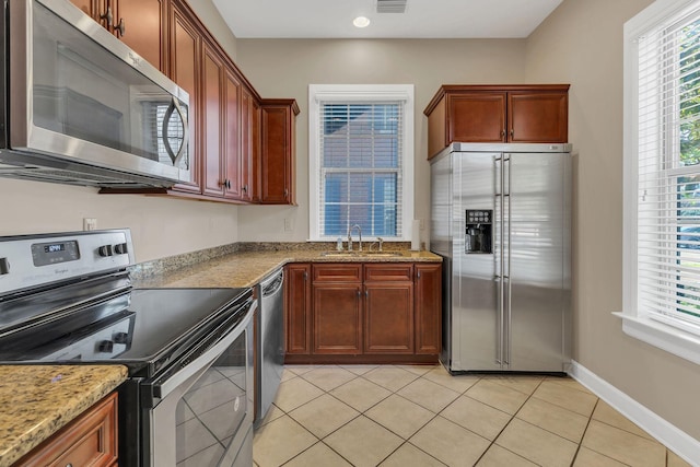 307 Seven Springs Way Unit 402, Brentwood, TN 37027 - kitchen with appliances with stainless steel finishes, a sink, light tile patterned floors, light stone counters, and baseboards
