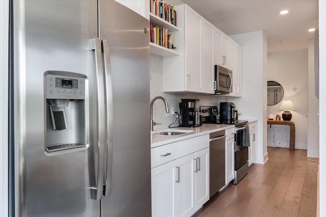 1041 E Trinity Ln Unit 419, Nashville, TN 37216 - kitchen featuring stainless steel appliances, a sink, light wood-style flooring, light countertops, and white cabinetry