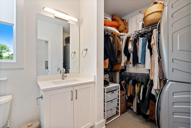 1041 E Trinity Ln Unit 419, Nashville, TN 37216 - walk in closet featuring estacked washer and dryer, a sink, and light colored carpet