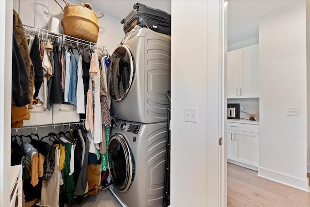 1041 E Trinity Ln Unit 419, Nashville, TN 37216 - laundry room featuring stacked washer and clothes dryer, light wood-style floors, and baseboards