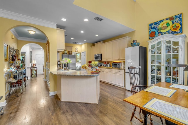 1552 Charleston Blvd, Murfreesboro, TN 37130 - kitchen with stainless steel microwave, freestanding refrigerator, light stone counters, arched walkways, and dark wood-style floors