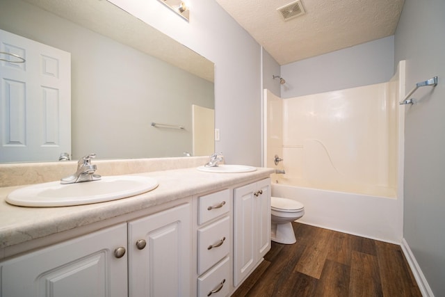 534 Mckean Dr, Smyrna, TN 37167 - full bath with toilet, wood finished floors, double vanity, shower / bath combination, and a textured ceiling