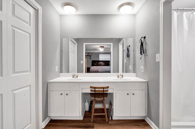 4028 Tomahawk Cir NW, Cleveland, TN 37312 - bathroom with wood finished floors, double vanity, a shower with shower curtain, ensuite bathroom, and baseboards