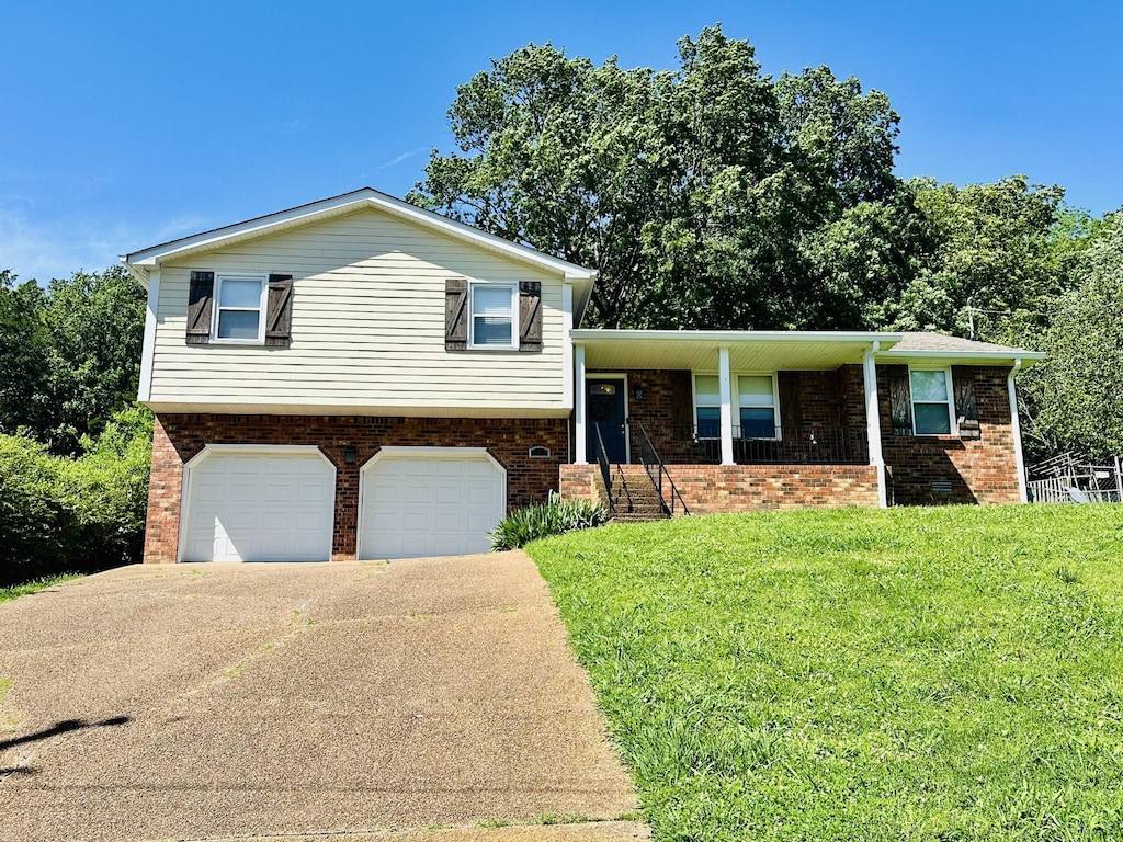 2432 Ponderosa Way, Antioch, TN 37013 - tri-level home featuring an attached garage, a front yard, driveway, brick siding, and covered porch
