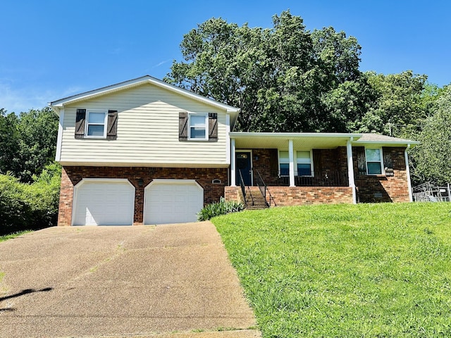 2432 Ponderosa Way, Antioch, TN 37013 - tri-level home featuring an attached garage, a front yard, driveway, brick siding, and covered porch
