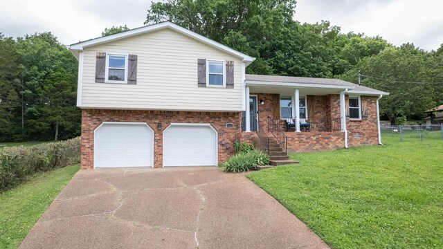 2432 Ponderosa Way, Antioch, TN 37013 - tri-level home featuring an attached garage, concrete driveway, brick siding, and covered porch