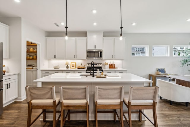 1705 Merkel Rd, Columbia, TN 38401 - kitchen featuring appliances with stainless steel finishes, a breakfast bar area, backsplash, light countertops, and dark wood finished floors