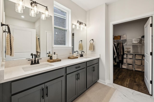 1705 Merkel Rd, Columbia, TN 38401 - bathroom featuring double vanity, marble look tiles, a spacious closet, and baseboards