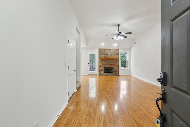2889 Sharpie Dr, Clarksville, TN 37040 - unfurnished living room with ceiling fan, light wood finished floors, a stone fireplace, baseboards, and vaulted ceiling