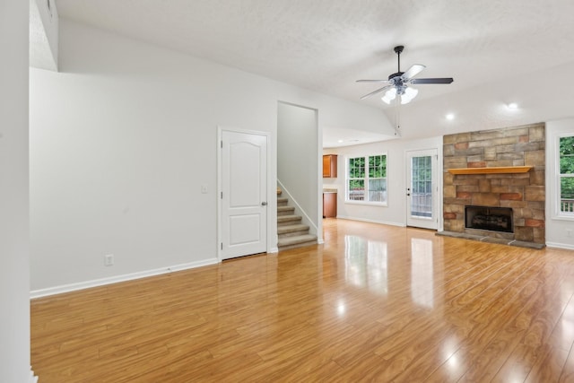 2889 Sharpie Dr, Clarksville, TN 37040 - unfurnished living room with lofted ceiling, ceiling fan, stairway, light wood-style floors, and a fireplace