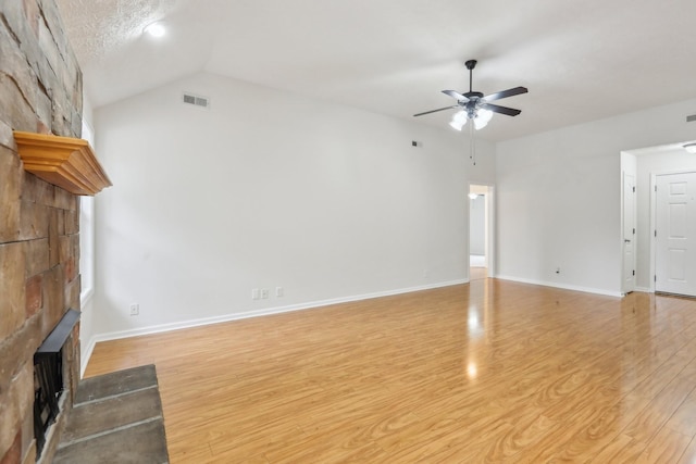 2889 Sharpie Dr, Clarksville, TN 37040 - unfurnished living room featuring a large fireplace, ceiling fan, light wood-style flooring, baseboards, and vaulted ceiling