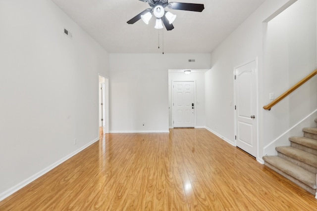 2889 Sharpie Dr, Clarksville, TN 37040 - unfurnished living room with ceiling fan, stairway, light wood-style flooring, and baseboards