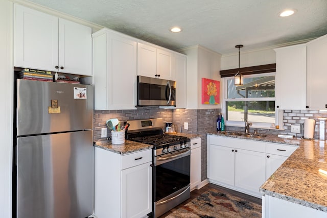 440 Bluff Point Ln, Waverly, TN 37185 - kitchen featuring appliances with stainless steel finishes, a sink, white cabinetry, decorative backsplash, and light stone counters
