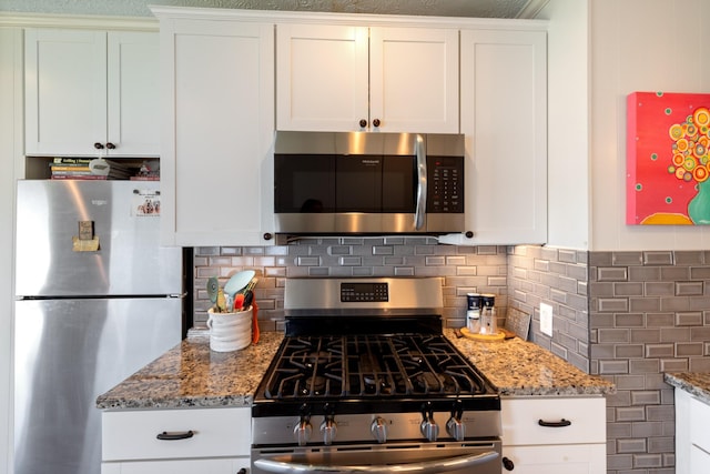 440 Bluff Point Ln, Waverly, TN 37185 - kitchen featuring appliances with stainless steel finishes, light stone countertops, and white cabinets