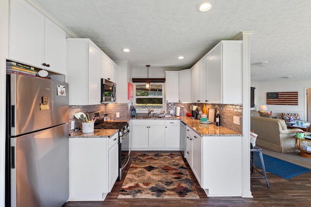 440 Bluff Point Ln, Waverly, TN 37185 - kitchen featuring stainless steel appliances, a textured ceiling, light stone counters, white cabinetry, and a sink