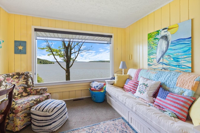 440 Bluff Point Ln, Waverly, TN 37185 - living area with plenty of natural light, carpet flooring, a textured ceiling, wood walls, and a water view
