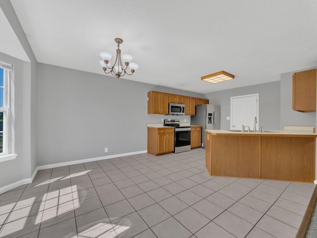 3825 Roscommon Way, Clarksville, TN 37040 - kitchen with stainless steel appliances, a chandelier, a peninsula, light countertops, and baseboards