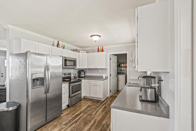 84 Del Toro Dr, Sparta, TN 38583 - kitchen with stainless steel appliances, washer / clothes dryer, ornamental molding, white cabinetry, and dark wood-style flooring