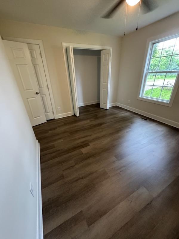 803 17th Ave E, Springfield, TN 37172 - unfurnished bedroom featuring dark wood-type flooring, baseboards, ceiling fan, and a closet