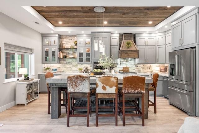 2878 Fly Rd, Santa Fe, TN 38482 - kitchen with appliances with stainless steel finishes, gray cabinetry, custom range hood, a raised ceiling, and a center island