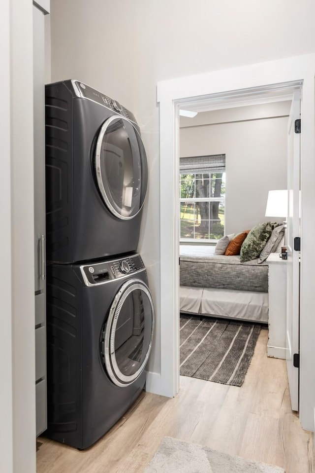 2878 Fly Rd, Santa Fe, TN 38482 - laundry room featuring stacked washing machine and dryer, light wood finished floors, and baseboards