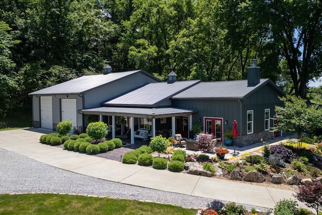 2878 Fly Rd, Santa Fe, TN 38482 - view of front facade with a chimney, metal roof, driveway, board and batten siding, and a patio