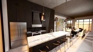 117 E 7th St Unit 902, Chattanooga, TN 37402 - kitchen featuring custom exhaust hood, stainless steel refrigerator, and a breakfast bar