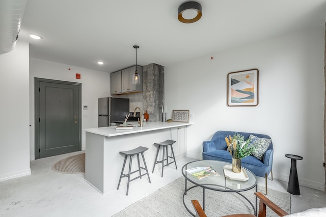 117 E 7th St Unit 302, Chattanooga, TN 37402 - kitchen featuring freestanding refrigerator, a peninsula, a breakfast bar area, light countertops, and a sink