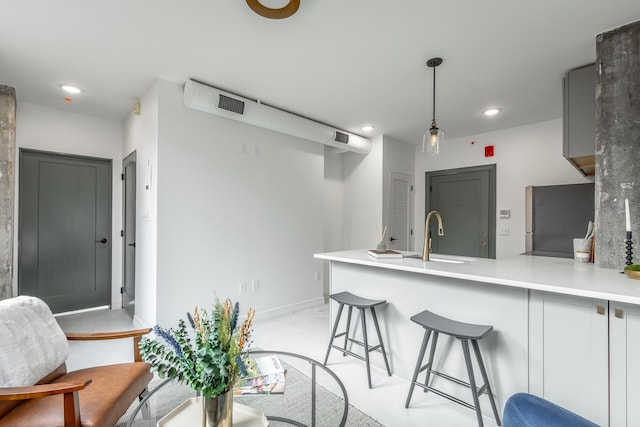 117 E 7th St Unit 302, Chattanooga, TN 37402 - kitchen with freestanding refrigerator, a peninsula, a sink, recessed lighting, and a kitchen breakfast bar